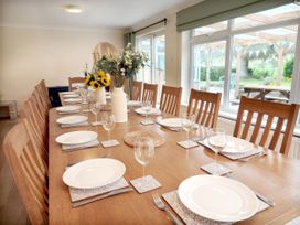 A dining room with a large table set for meal at Bush Nook House in Brampton, Cumbria