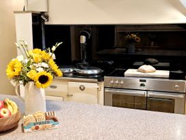 A kitchen with stove and a bowl of fruit at Bush Nook House in Brampton, Cumbria