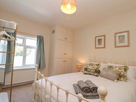A bedroom with a bed and window at Moot Cottage Driffield