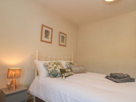 A bedroom with a bed and lamp at Moot Cottage in Driffield