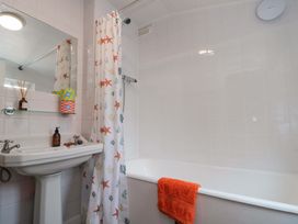 A bathroom with a bathtub and sink at Moot Cottage in Driffield