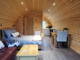 A living room with a bed and kitchen area at Lodge 1 in Pontyates
