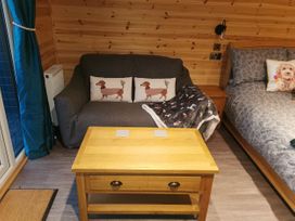 A living room with a sofa and coffee table at Lodge 1 in Pontyates