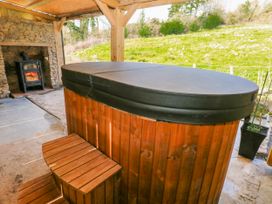 A hot tub with steps and a fireplace at Lodge 1 near Pontyates