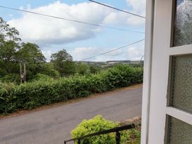 A view from a property showing a road, trees, and fields at 5 Hollins Cottages in Whitby