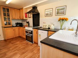 A kitchen with cabinets, a sink, and appliances at 5 Hollins Cottages in Whitby