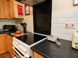 A kitchen with an oven, microwave, and countertop items at 5 Hollins Cottages in Whitby