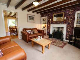 A living room with a sofa and fireplace at 5 Hollins Cottages in Whitby