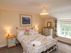 A bedroom with a bed and dresser at 5 Hollins Cottages in Whitby