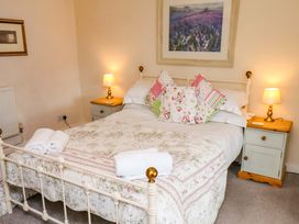 A bedroom with a bed and lamp at 5 Hollins Cottages in Whitby