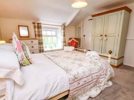 A bedroom with a bed and wardrobe at 5 Hollins Cottages in Whitby