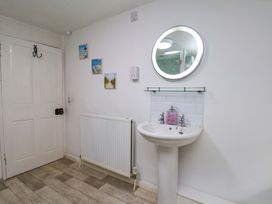 A bathroom with a sink and mirror at 5 Hollins Cottages in Whitby