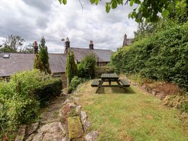A garden with a picnic table and trees at 5 Hollins Cottages in Whitby