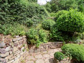 A garden with a stone wall and various plants at 5 Hollins Cottages in Whitby