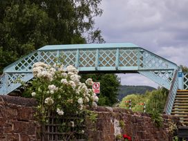 A bridge with flowers in front and a stone wall near The Old Barn in Whitby