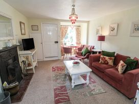 A living room with a sofa, coffee table, and television at Pebble in Blakeney, Norfolk