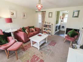 A living room with a sofa and side table at Pebble in Blakeney, Norfolk
