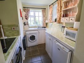 A kitchen with a washing machine and sink at Pebble, Blakeney, Norfolk