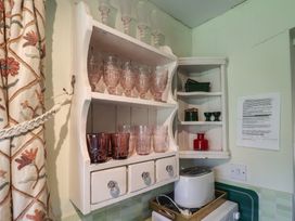 A kitchen with glassware on shelves and a toaster at Pebble in Blakeney, Norfolk