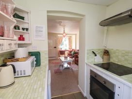 A kitchen with appliances and a view to the living room at Pebble Blakeney, Norfolk