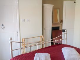 A bedroom with a bed and wardrobe at Pebble in Blakeney, Norfolk