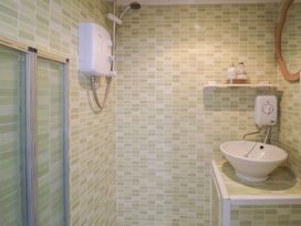 A bathroom with a shower and washbasin at Pebble in Blakeney, Norfolk