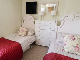 A bedroom with two single beds and a chest of drawers at Pebble in Blakeney, Norfolk