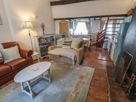 A living room with a sofa and coffee table at Buttercup in Blakeney, Norfolk