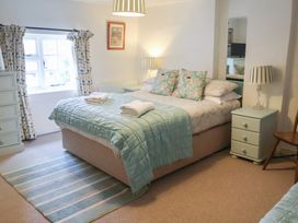 A bedroom with bed and bedside table at Buttercup in Blakeney, Norfolk