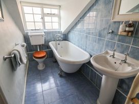 A bathroom with a bathtub, toilet and sink at Buttercup in Blakeney, Norfolk