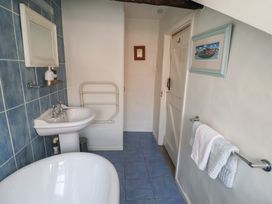 A bathroom with a bathtub and sink at Buttercup, Blakeney, Norfolk