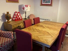 A dining room with a wooden table and red chairs at The Bittern in Blakeney, Norfolk