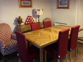 A dining room with a wooden table and red chairs at The Bittern in Blakeney, Norfolk