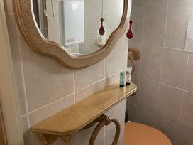 A bathroom with a mirror and toiletries on a shelf at The Bittern in Blakeney, Norfolk