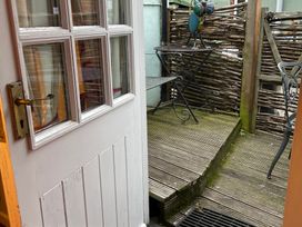 An outdoor area with a door leading to a table and chair at The Bittern in Blakeney, Norfolk