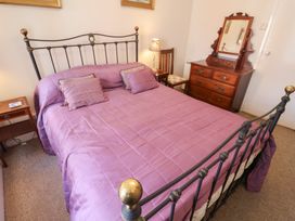 A bedroom with a bed and wooden furniture at The Plover in Blakeney, Norfolk