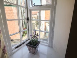 A window with a flower pot overlooking a courtyard at The Plover in Blakeney, Norfolk