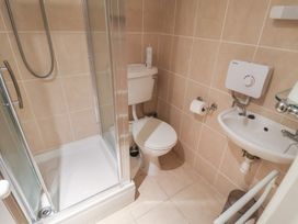 A bathroom with a shower, toilet, and sink at The Plover in Blakeney, Norfolk