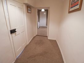 A hallway with a door and light fixture at The Plover in Blakeney, Norfolk