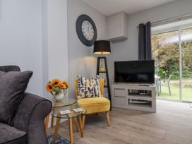 A living room with a television and a sofa at Beach Hideaway