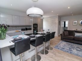 A kitchen with bar stools and a dining area at Beach Hideaway