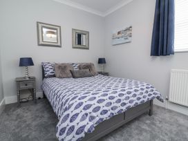 A bedroom with a bed and bedside table at Beach Hideaway 