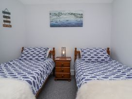 A bedroom with two beds and a lamp on a nightstand at Beach Hideaway