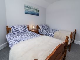 A bedroom with two single beds and a nightstand at Beach Hideaway