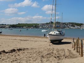 A boat on a beach with water and hills in the background at Beach Hideaway