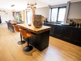 A kitchen with a bar island and dining table at Holly Farm in Colchester