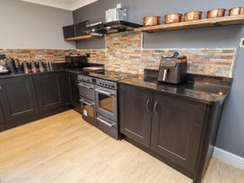 A kitchen with an oven and countertop appliances at Holly Farm in Colchester
