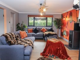 A living room with a blue sofa and a coffee table at Holly Farm in Brantham