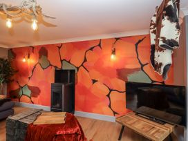 A living room with a television and wooden furniture at Holly Farm in Brantham