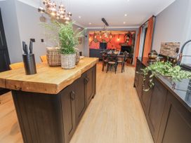 A kitchen with a wooden island and dining area at Holly Farm in Brantham